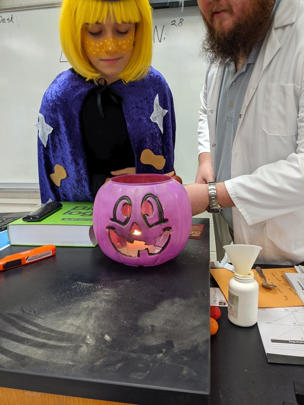 student and teacher conducting a science experiment in costume