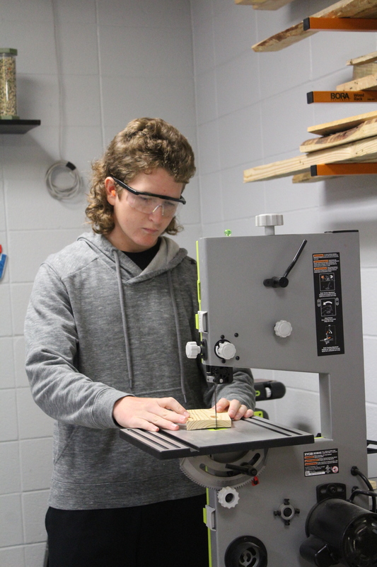 Braden Doherty uses the band saw to cut wood to correct dimensions.